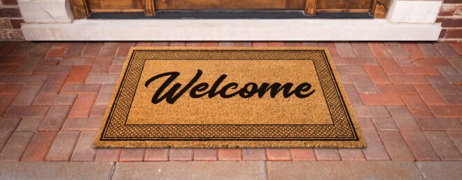 Welcome doormat on a brick porch